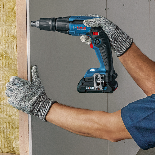 Destornillador a batería Bosch GTB18V-45 sujetado por una persona que lleva guantes de protección contra una pared, con "CORE" y "4 Ah" visibles.