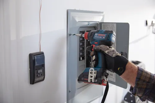 GDX18V-1800 HD atornillador de impacto Bosch siendo utilizado en un panel de disyuntores. También se puede ver un control de abridor de puerta de garaje Chamberlain.