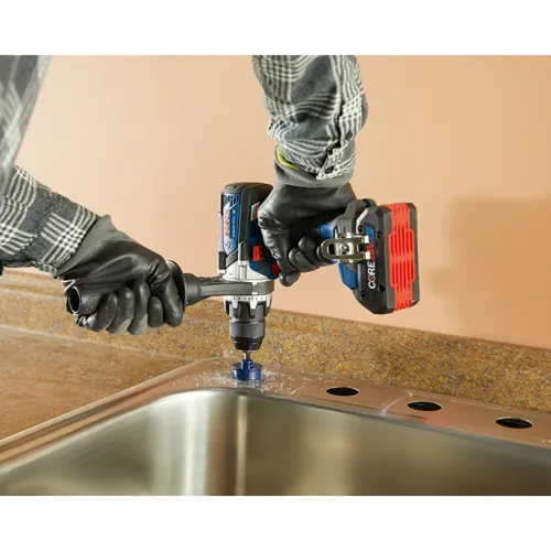 Bosch GSB18V-975C HD taladro percutor con una sierra de corona cortando un agujero en un fregadero metálico.