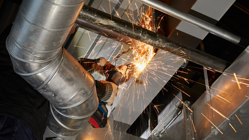 Amoladora angular inalámbrica Bosch emitiendo chispas al cortar un tubo de metal.