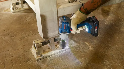 Llave de impacto a batería Bosch GDS18V-330PC con batería CORE18V 4.0Ah utilizada para trabajar en una estructura metálica.