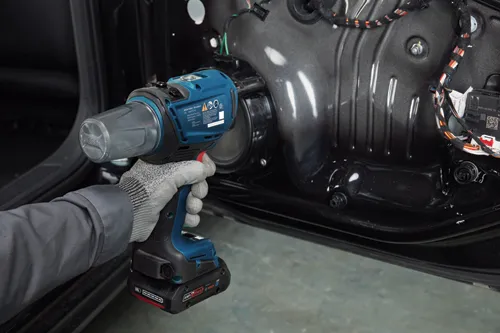 Bosch GRG18V-3600C 3601JK5010, pistola de calor de 18V, sostenida por una persona que lleva un guante.