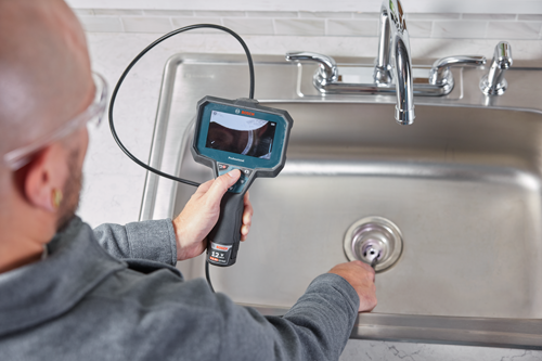 Cámara de inspección Bosch Professional en uso, con batería de 12 V MAX 2.0 Ah Li-Ion, inspeccionando un desagüe de fregadero.