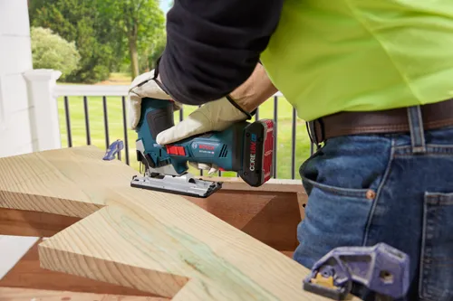 Bosch GST18V-50B HD sierra de calar, con batería CORE18V 4.0 Ah, cortando una tabla de madera.