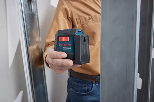 Bosch Professional GLL50-20 nivel sostenido por una persona. Se ven los botones "OFF" y "ON".