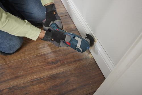 Bosch GOP18V-28 herramienta multiuso oscilante sin escobillas cortando rodapié.