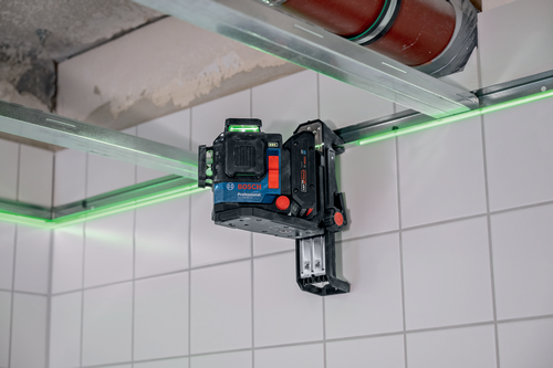 Nivel Bosch Professional GLL3-80CG, con líneas láser verdes, montado en una pared de azulejos blancos.