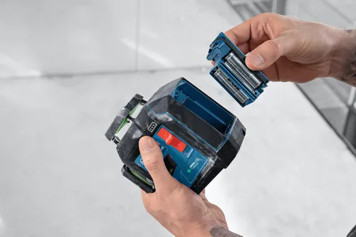Bosch nivel con TECNOLOGÍA LÁSER VERDE, con una persona insertando baterías.