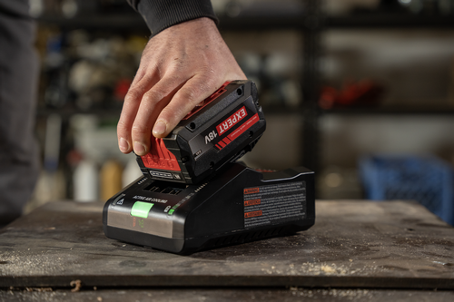 A worker inserting a Bosch EXBA18V-80 EXPERT 18V Lithium-Ion 8 Ah High Power Battery into GAL18V-160 Battery Turbo Charger.