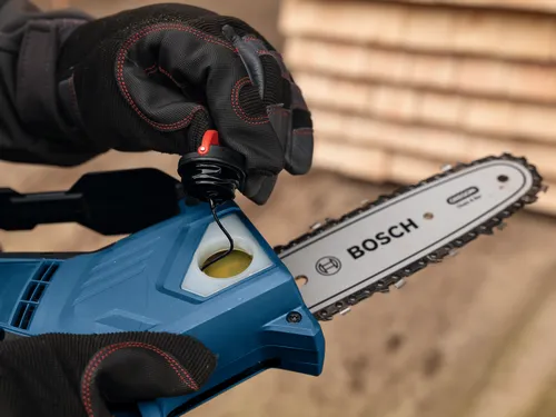 Close-up image of worker removing the cap of Bosch GKE18V-20 18V Pruning Saw.