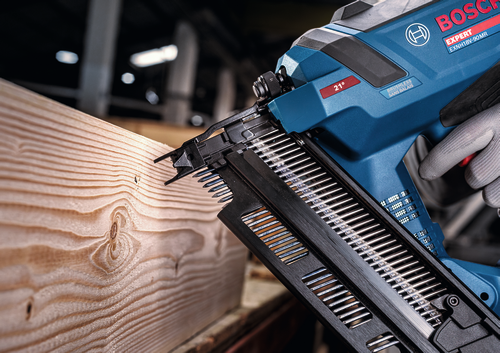 Imagen de un trabajador usando la pistola de clavos para estructuras Bosch EXNH18V-90MRN EXPERT de 18 V en una tabla de madera.