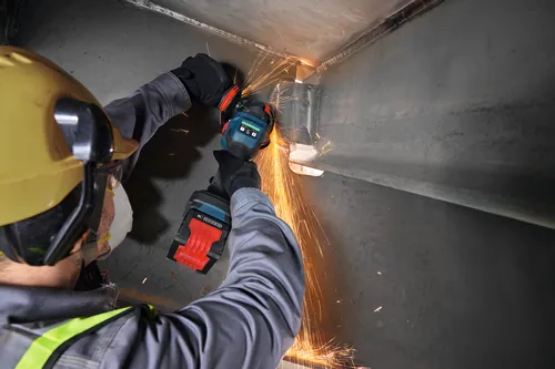 Un trabajador amolando un metal con la amoladora angular sin escobillas Bosch EXWS18V-15S de 18 V y 6" con interruptor de paleta sin bloqueo.