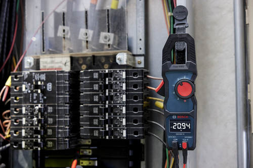 Imagen de estilo de vida del amperímetro Bosch GMC600-15 True RMS de 400 A cerca de un cuadro eléctrico.