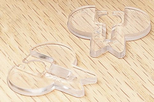 Dos conectores de plástico transparente sobre una superficie con veta de madera.