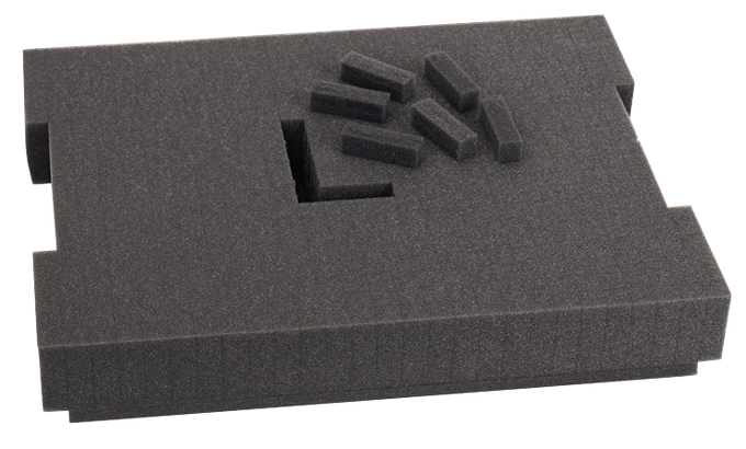 Inserto de espuma gris oscuro con huecos y pequeñas piezas rectangulares de espuma.