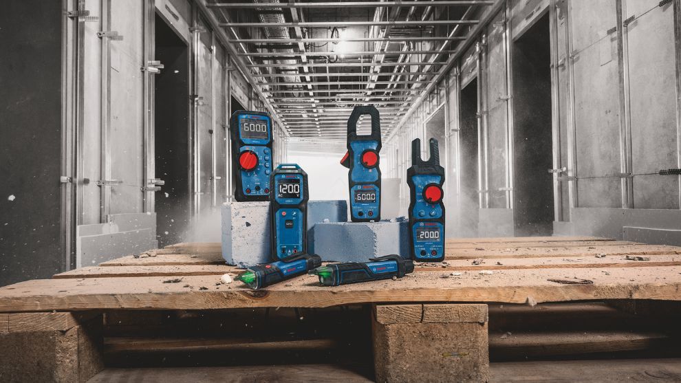 Una colección de herramientas Bosch Professional en azul, colocadas sobre palets de madera, rodeadas de escombros de construcción.